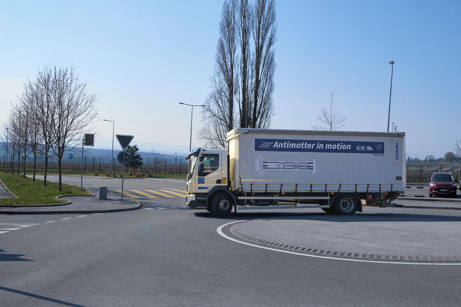 Ein weißer Lastwagen fährt um einen Kreisel.