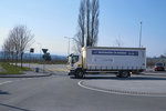 Ein weißer Lastwagen fährt um einen Kreisel.