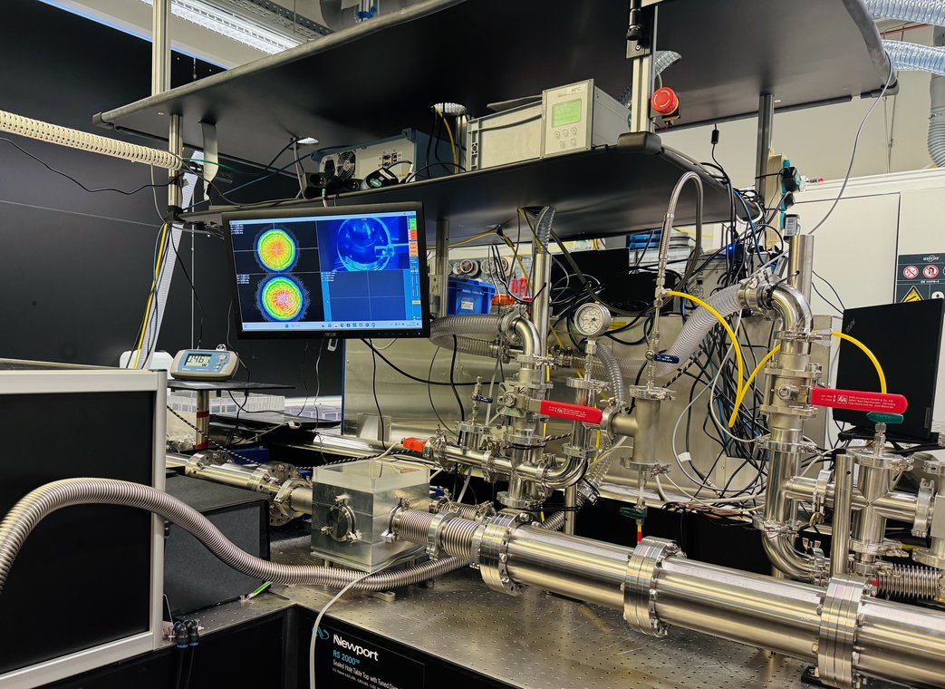 A complex measurement setup consisting of silver tubes, cables and a screen is located on a table. A complex measurement setup consisting of silver tubes, cables and a screen is located on a table.