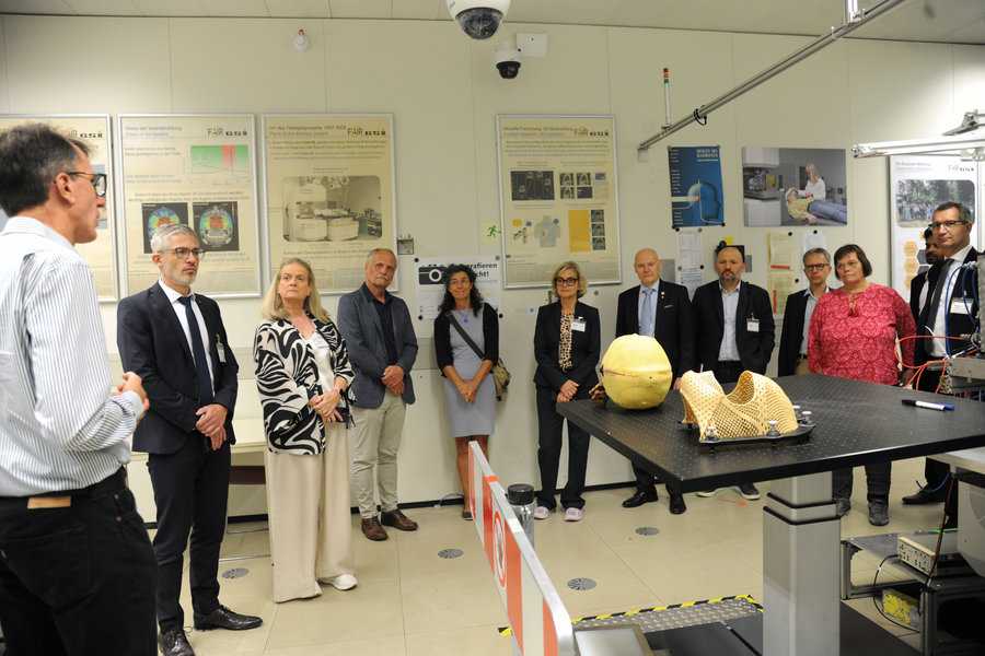Visit at biophysics research Eine Gruppe Personen steht in einem Raum und betrachtet einen Tisch mit zwei medizinischen Maske.