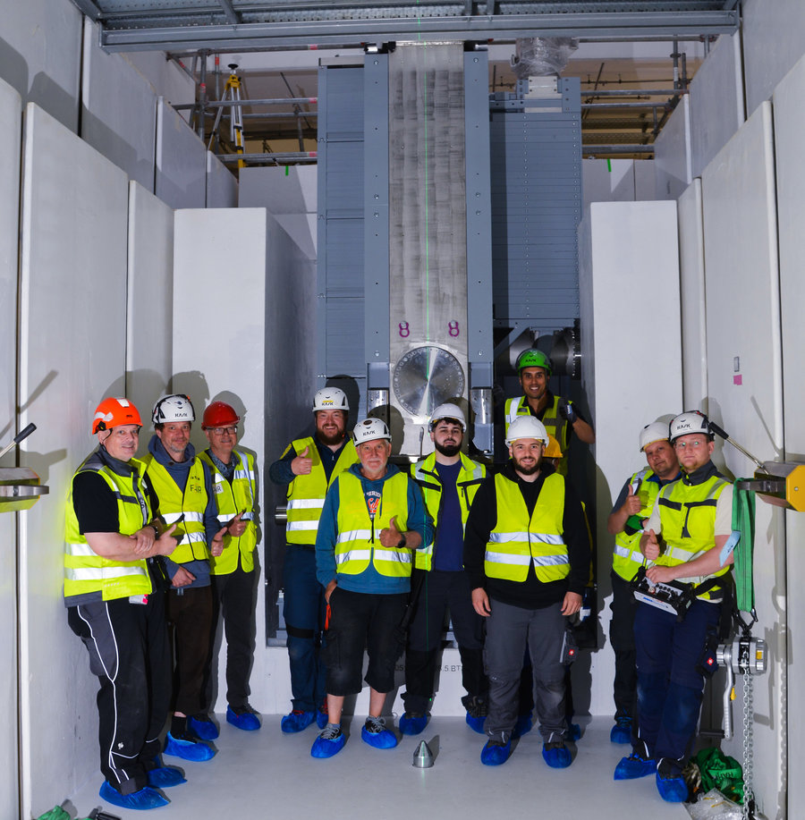 Installation is complete Eine Gruppe Menschen steht vor der Targetkammer im Inneren des Tunnels