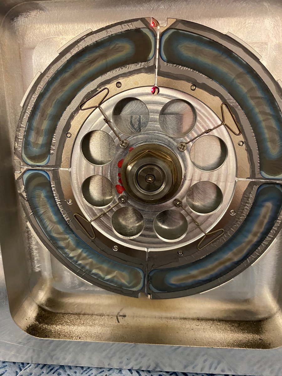 Das TASCA Targetrad mit einem Durchmesser von 10 cm und den vier Segmenten mit Blei-208 auf 500 nm dünnen Kohlenstofffolien. Der intensive Chrom-52 Strahl hat die Morphologie der bestrahlten Bereiche verändert, sichtbar an der Verfärbung.