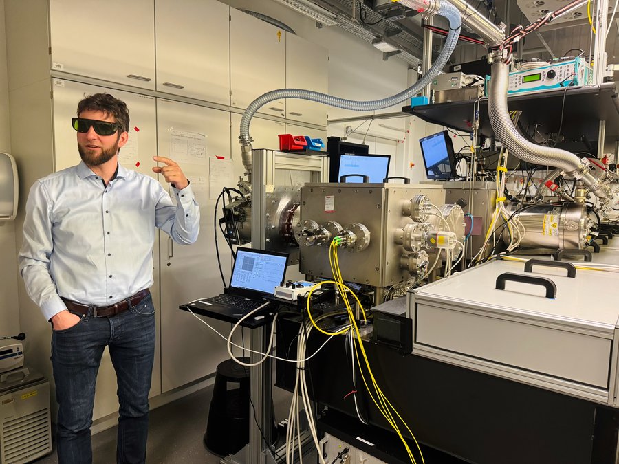 Forscher Jan Rothhardt steht vor einem Experimentaufbau