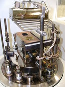 Detail: Electron beam gun with substrate holder and quartzheater In the picture you see the electron beam gun under a substrate holder and a quartz lamp for substrate heating