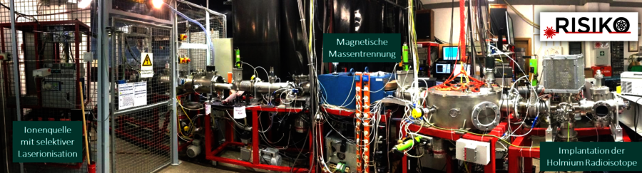 The RISIKO mass separator at the JGU Institute of Physics, where holmium radioisotopes are implemented into the ECHo detector pixels. Auf einem roten Gestell sind mehrere Kammern und Rohre zu sehen, an die viele Kabel angeschlossen sind.