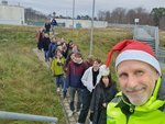 Visit of the participants at the FAIR viewpoint Eine Reihe Menschen steht in einer Schlange im Grünen. Ganz vorne steht ein Mann mit Nikolausmütze.