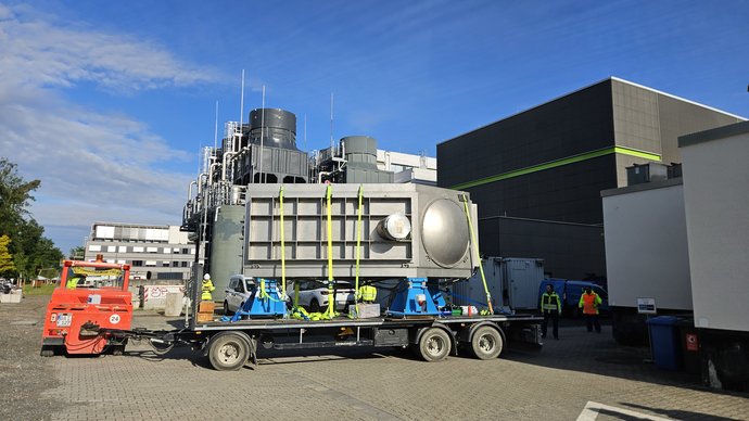 A large, silver metallic chamber is positioned on a trailer.