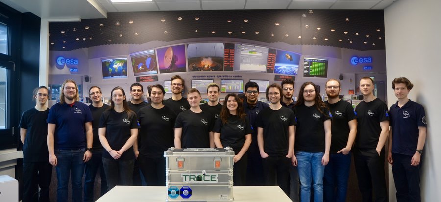 Das TRACE-Team Eine Gruppe Personen steht hinter einer silbernen Transportbox.