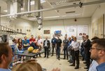 Eine Gruppe Personen steht im Halbkreis um einen Experimentaufbau.